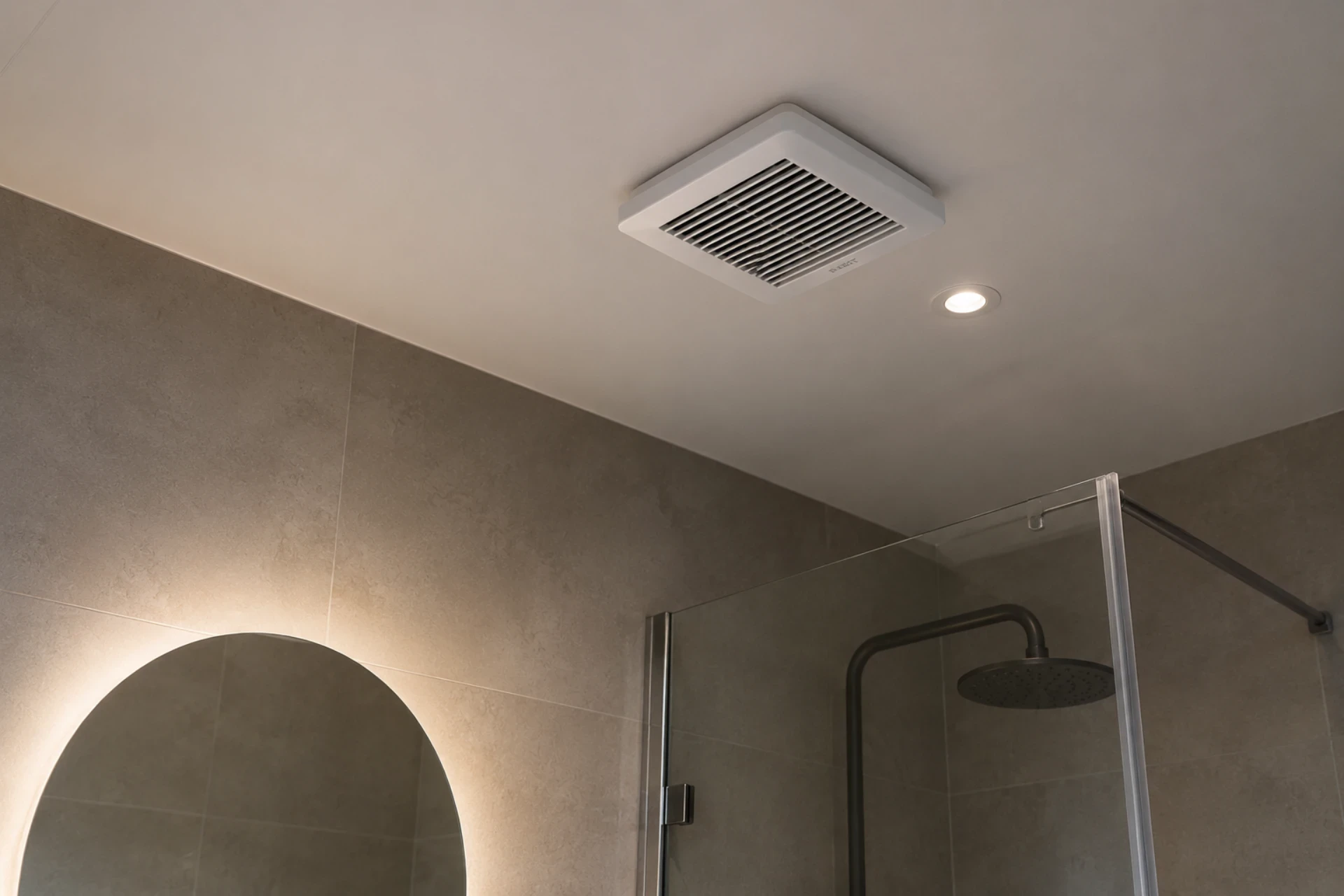 Moderne badeværelsesventilator og brusekabine med glasdør.