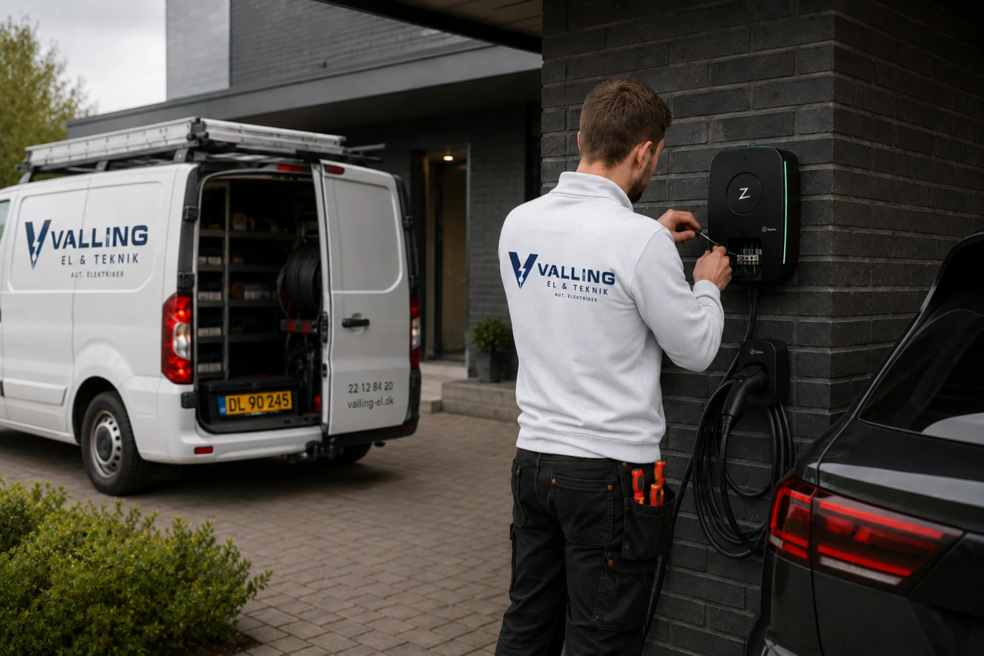Elektriker tilslutter ladestander til elbil foran Valling El & Teknik.
