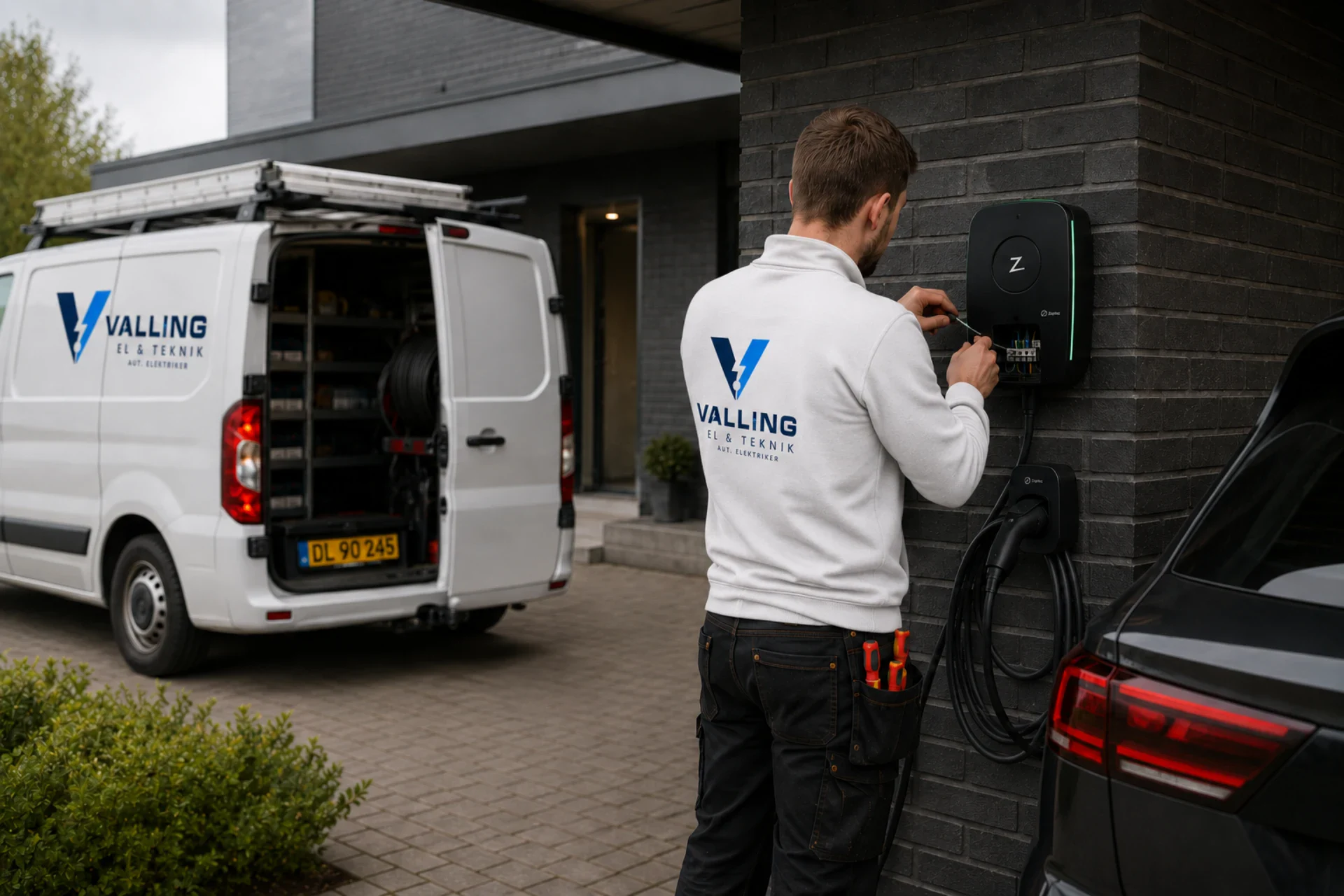 Elektriker installerer ladestander til elbil foran moderne hus.