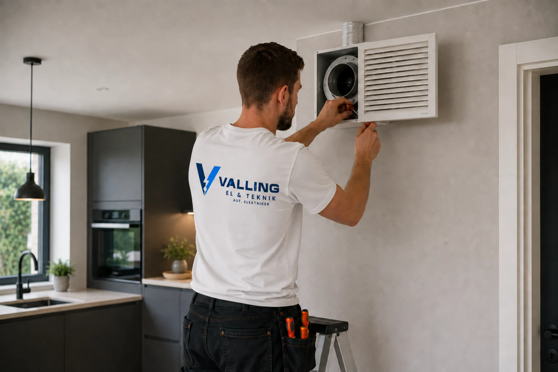 Elektriker installerer ventilationsfilter i vægventilationsenhed.